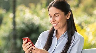 Frau auf Parkbank mit Smartphone